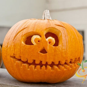 Carved Jack O' Lantern pumpkin with round eyes and toothy smile on outdoor surface